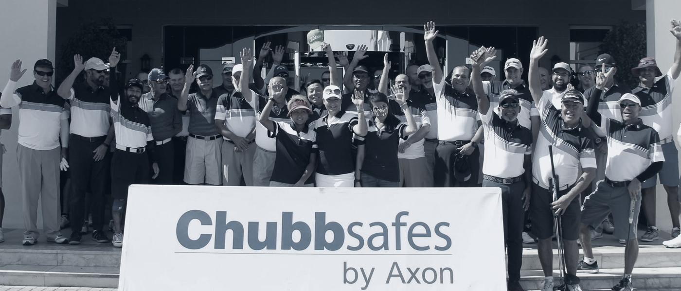 Group photo behind a Chubbsafes by Axon banner at a golf day