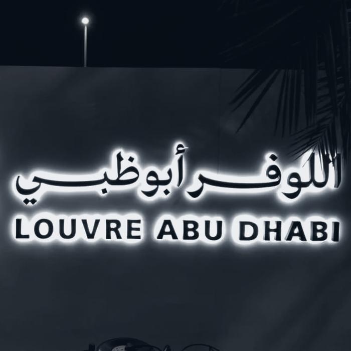 Backlit Louvre Abu Dhabi architectural lettering at night