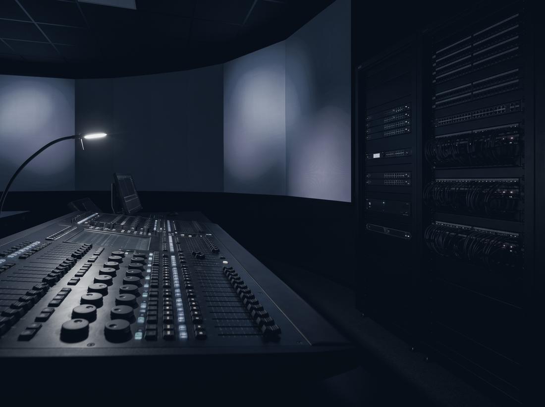 Audiovisual control room with lighting and audio console, display wall and equipment racks